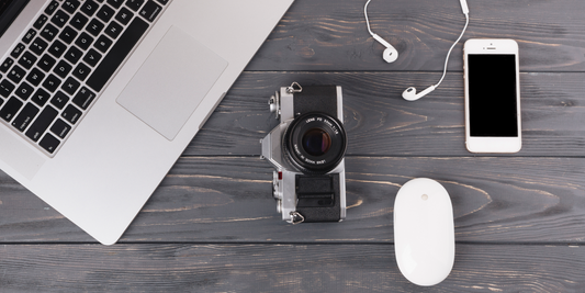 Black and silver camera beside MacBook Pro